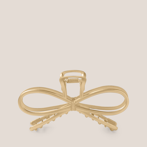 The Hair Edit Gilded Festive Bow Claw Clip on a beige background