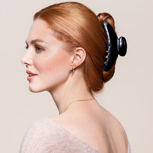 A woman wearing the Midnight Claw Clip in a French twist