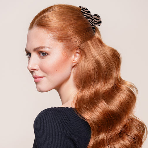 A woman wearing the Untamed Claw Clip in a half up half down hairstyle