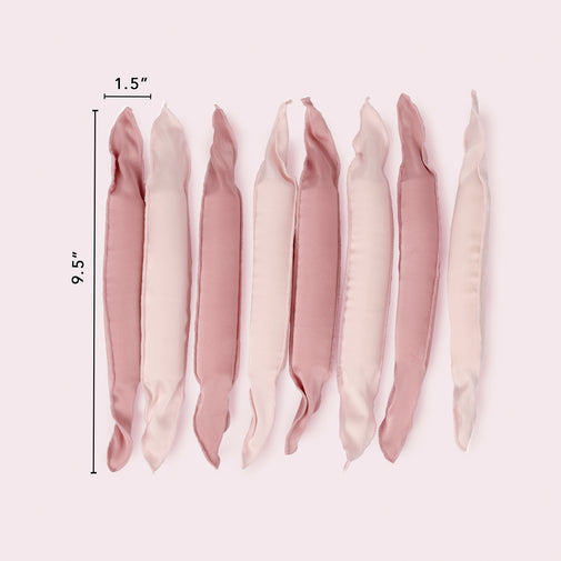 Six satin pillow rollers in dusty pink and cream shades, displayed vertically with black dimension lines indicating a height of 9.5 inches and a width of 1.