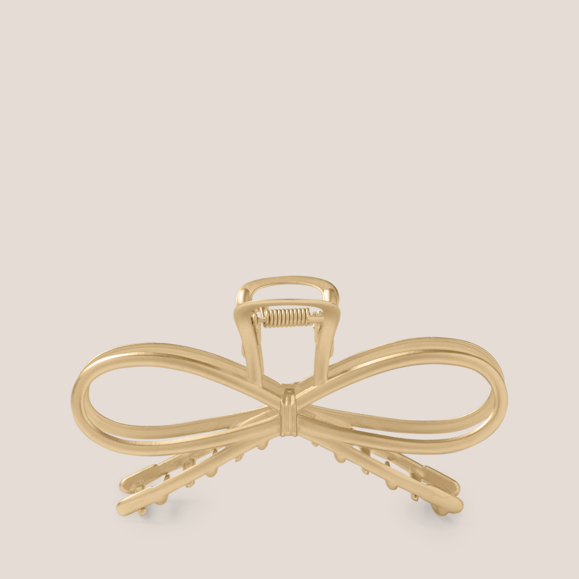 The Hair Edit Gilded Festive Bow Claw Clip on a beige background1