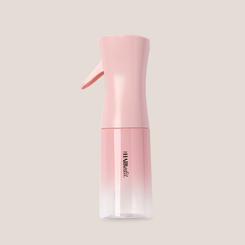 A pink cosmetic spray bottle with a gradient design that fades from solid pink at the top to clear at the bottom, featuring a small pink applicator nozzle on top. The brand name 'HARVEE' is printed vertically in black on the lower half.
