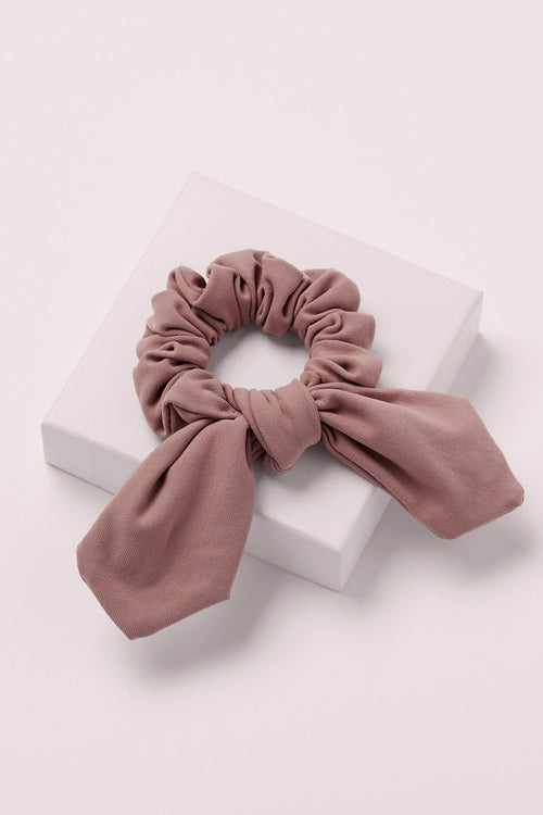 Bow Pose Knotted Ribbon Scrunchie on a pink box 
