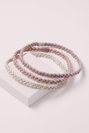 Salutation Slim Braided Headbands on a pink box 
