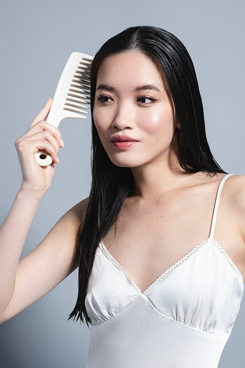 model with wet hair posing with white comb