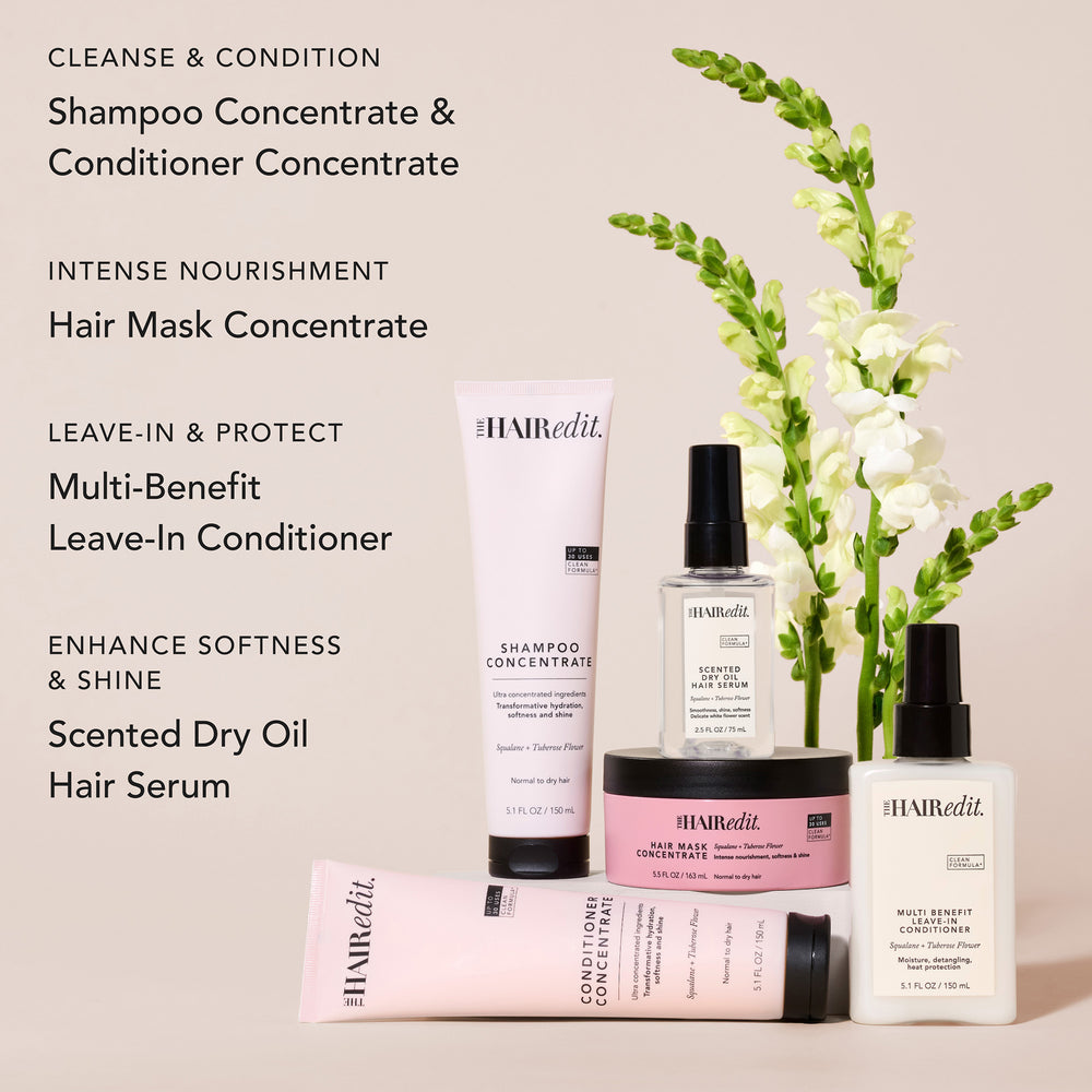 The Hair Edit haircare product lineup on a light beige background with black text callouts. Visible items include a small clear bottle of hair serum, a white tube of shampoo concentrate, a white bottle of leave-in conditioner, a pink tube of conditioner concentrate, and a pink jar of hair mask concentrate.11