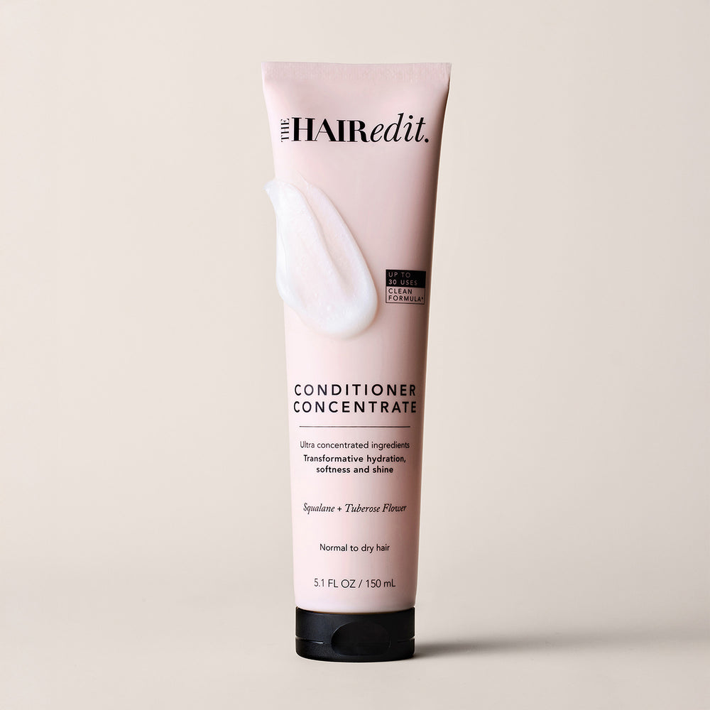 A 5.1 fl oz squeeze tube of The Hair Edit Conditioner Concentrate, shown on a light beige background.11
