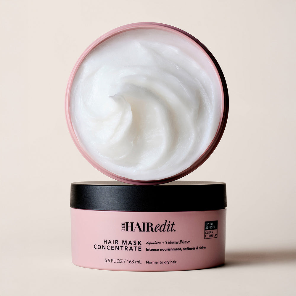 The Hair Edit Hair Mask Concentrate in a pink tub with a black lid, shown with the lid propped open to reveal the white cream inside, on a light beige background.12