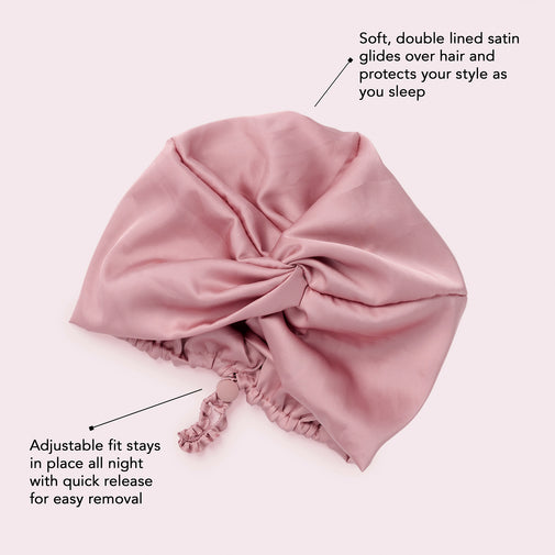 A dusty pink satin sleep cap with text callouts explaining its soft double lining, hair protection, and adjustable fit.