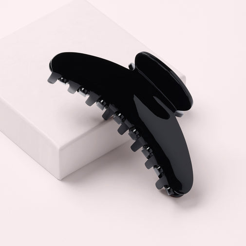 The Hair Edit Midnight Claw Clip on a pink box with a pink background