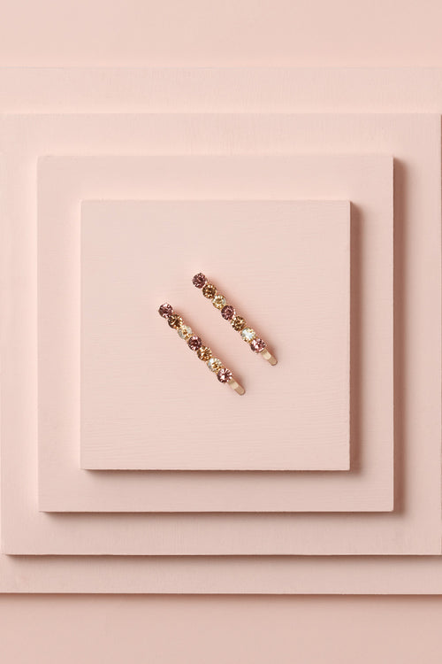 Glow On & Sparkle Gemstone Bobby Pins on a stack of pink boxes 