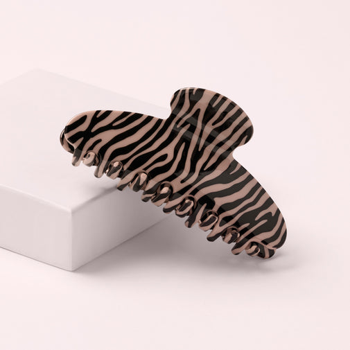 The Hair Edit Untamed Claw Clip on a pink box with a pink background