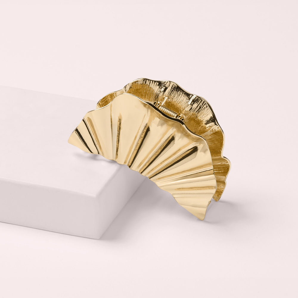 A gold-toned metallic fan-shaped claw clip displayed on a pink box5