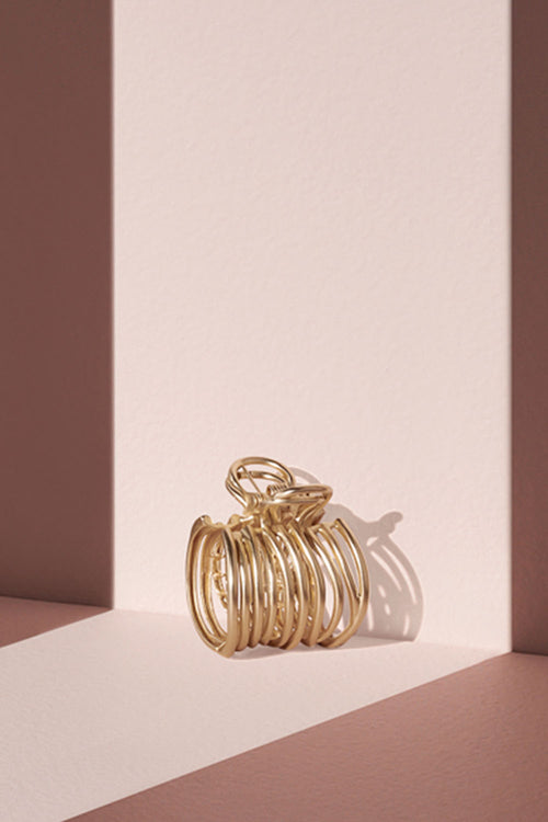 Camellia Gilded Wrap Cuff Claw Clip on a pink runway