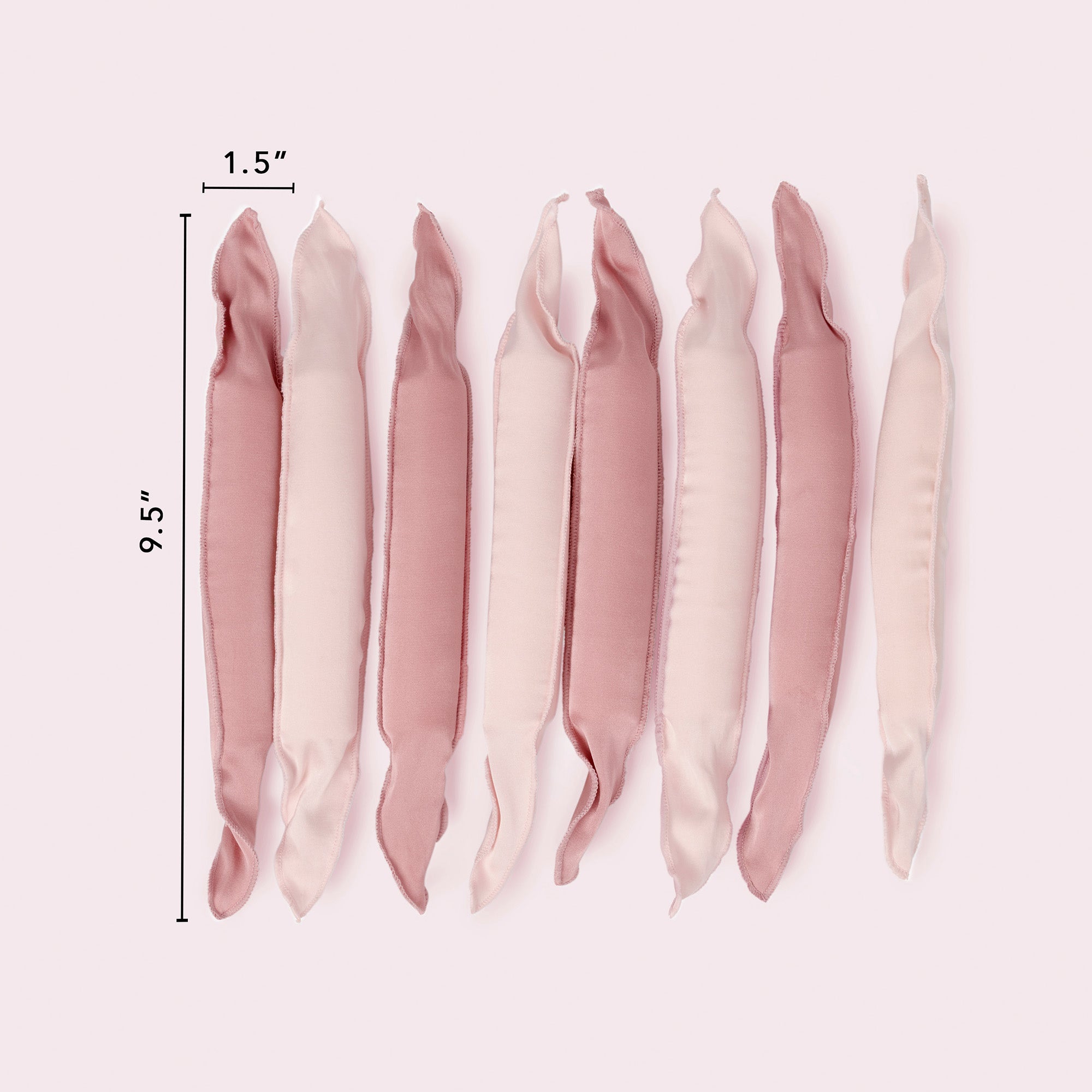 Six satin pillow rollers in dusty pink and cream shades, displayed vertically with black dimension lines indicating a height of 9.5 inches and a width of 1.6