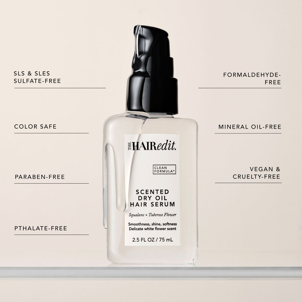 The Hair Edit Scented Dry Oil Hair Serum in a clear bottle with a black pump, centered on a light beige background with feature callouts around it.7