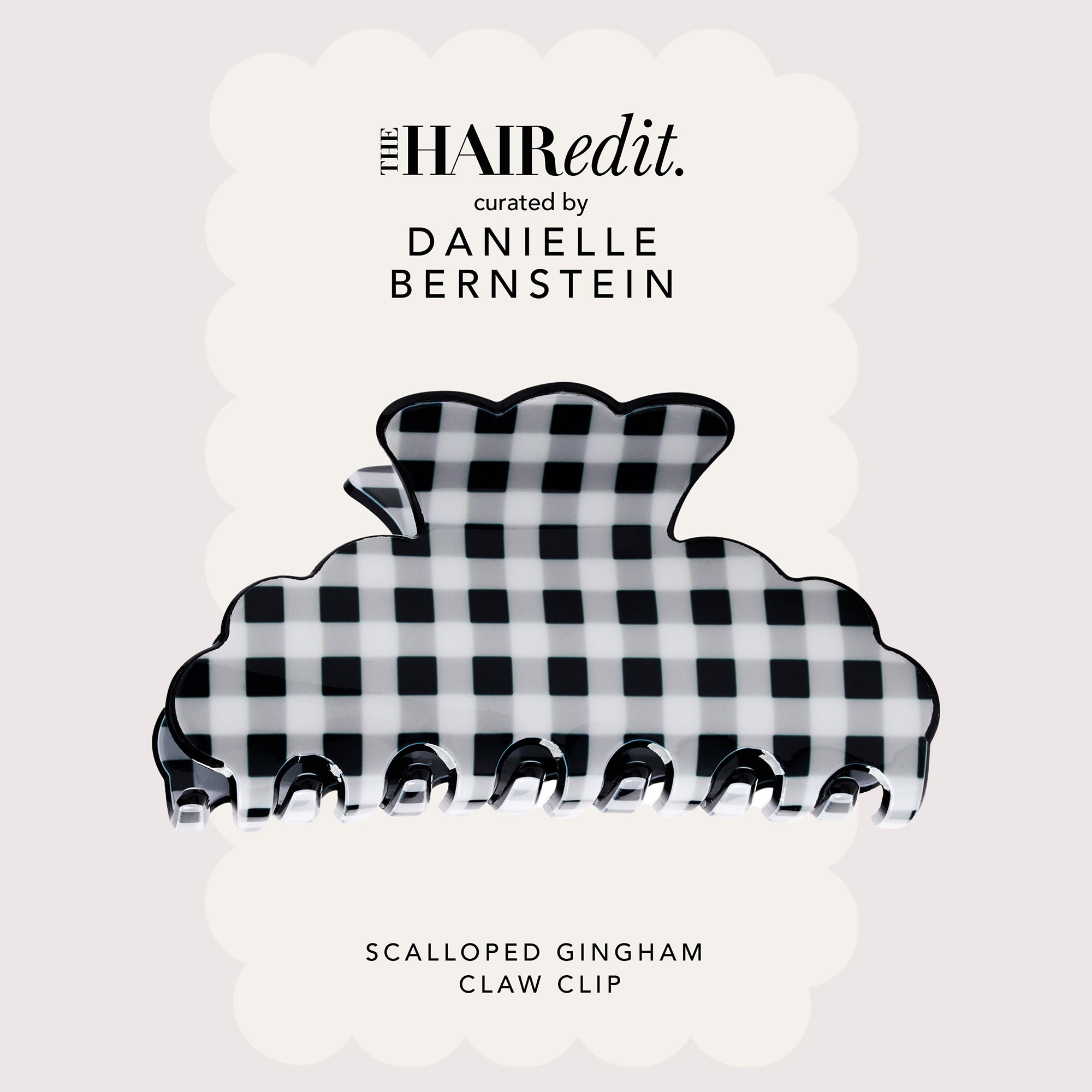 A scalloped black and white gingham claw clip centered on a pale pink background with decorative text reading 'THE HAIRedit. curated by DANIELLE BERNSTEIN' and 'SCALLOPED GINGHAM CLAW CLIP'.10
