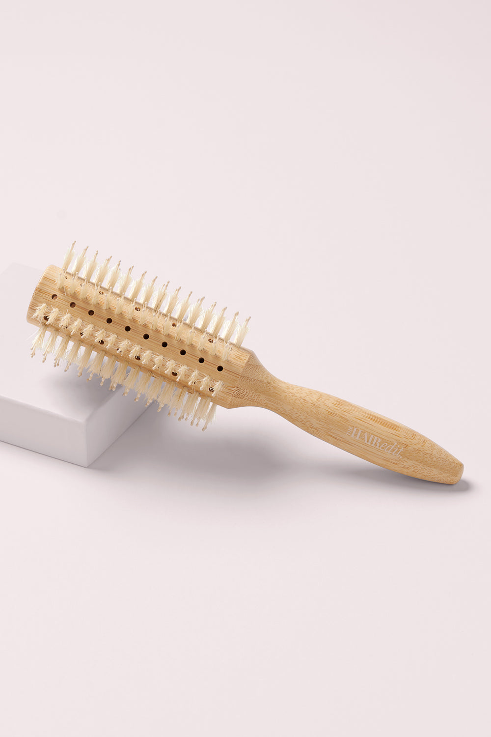 The Hair Edit Sleek Goddess Boar Bristle Bamboo Round Wood Brush on a pink box