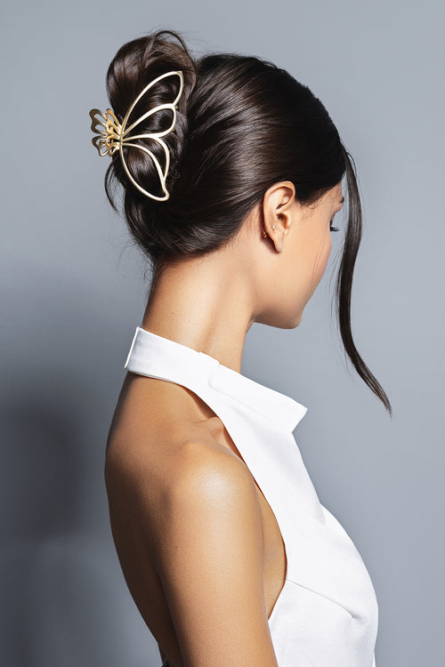 woman wearing gilded wing gold metal butterfly hair claw clip in hair