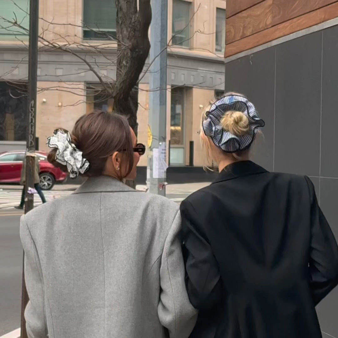 Video of Danielle Bernstein wearing  The Hair Edit's Oversized Polka Dot Ruffle Scrunchie and walking with model in streets of New York City2