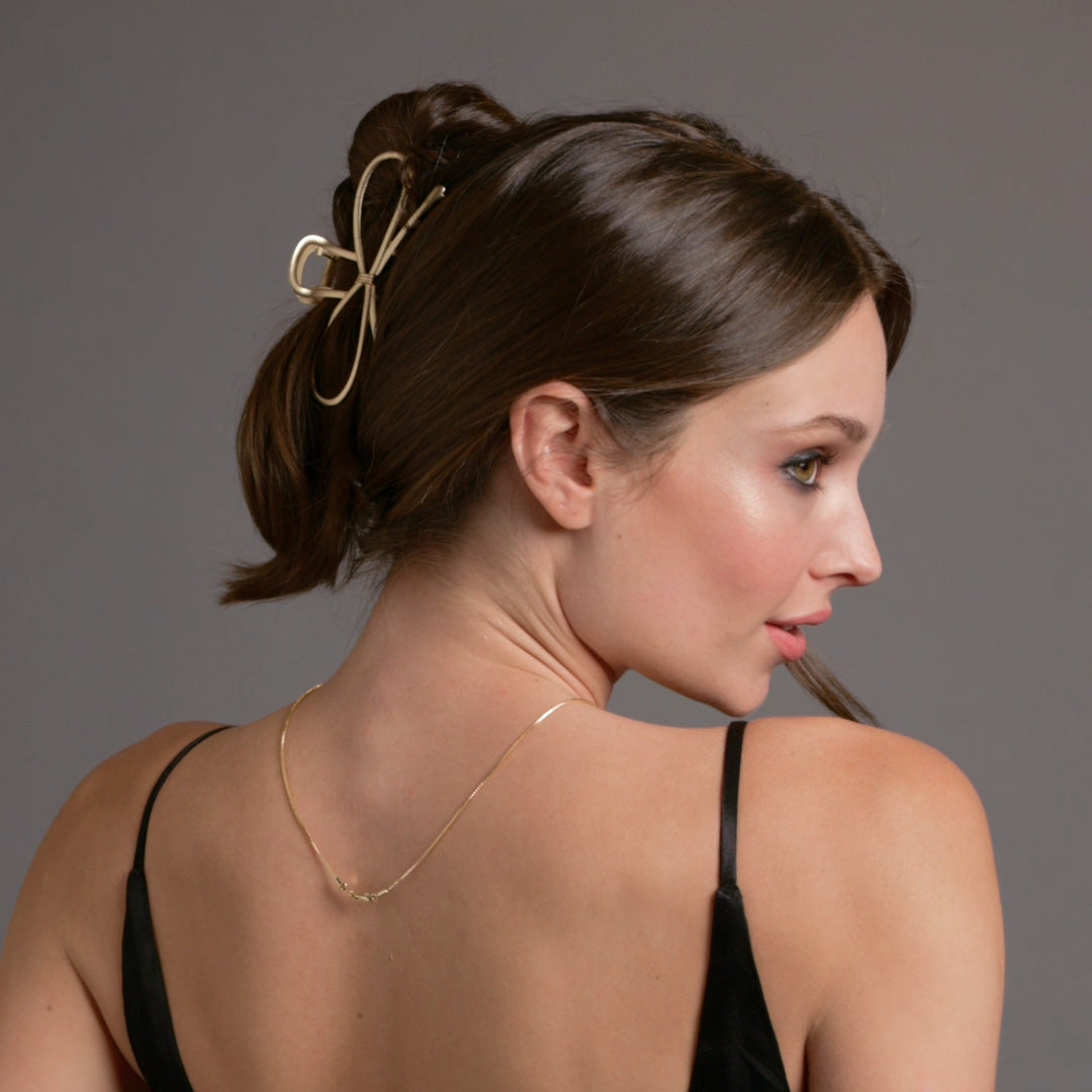 Video of model demonstrating how to wear The Hair Edit's Gilded Festive Bow Claw Clip2