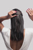 model putting hoop and pin barrette in her hair