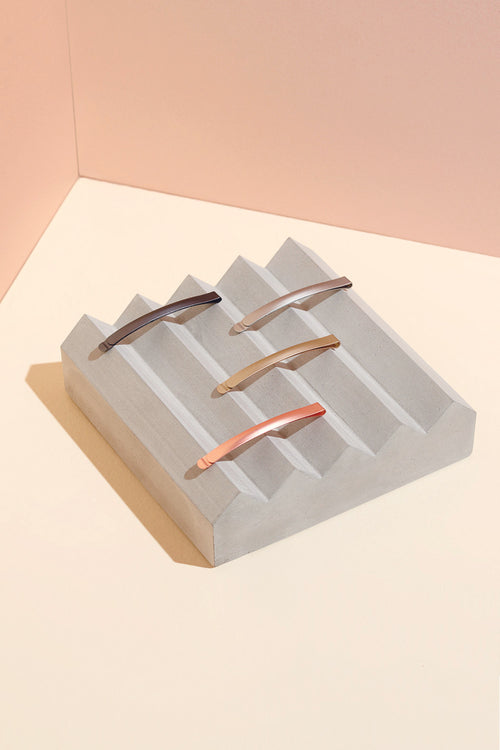 The Hair Edit Multicolored Gilded Metallic Bobby Pin Set in Pack of 4 Layout Displayed on top of Cement Block Jewelry Holder