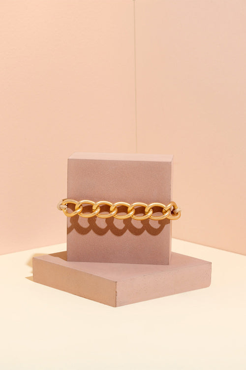 The Hair Edit Soft Gold Chain Wrap Metal Hair Tie on Pink Jewelry Display