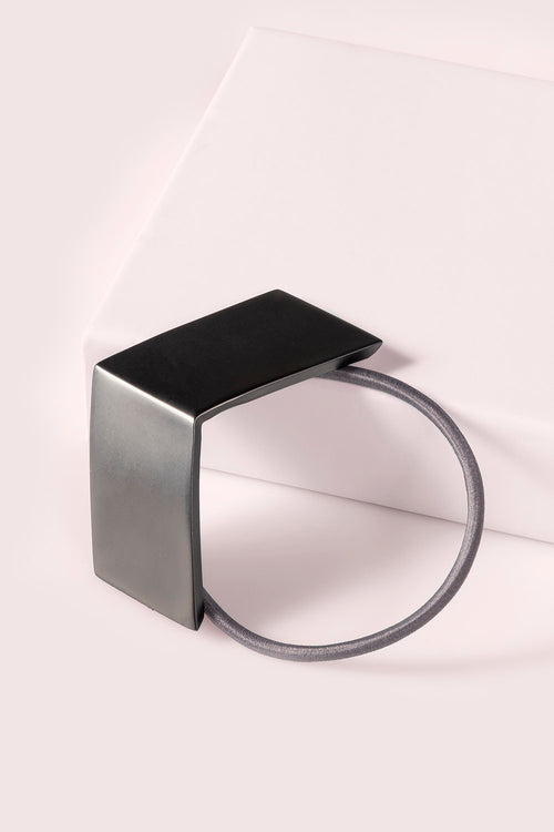 The Hair Edit black chevron geometric metal hair cuff tie against pink backdrop