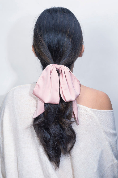 The Hair Edit Soft Blush Pink Oversized Ribbon Scrunchie Bow Hair Tie worn in ponytail by black wavy haired female model