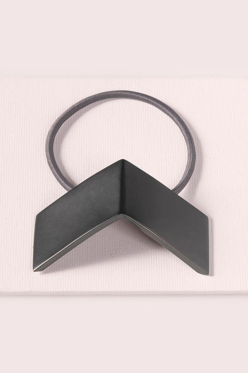 The Hair Edit black chevron geometric metal hair cuff & tie against pink backdrop