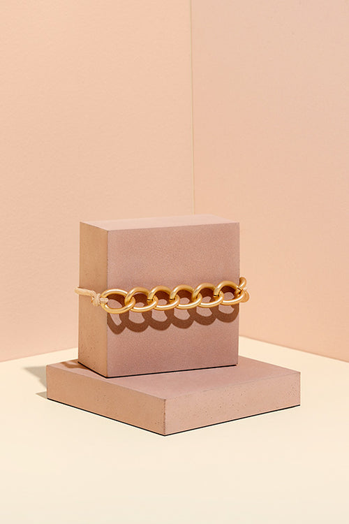 The Hair Edit Soft Gold Chain Wrap Metal Hair Tie on Pink Jewelry Display