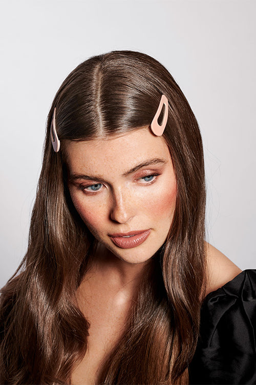 The Hair Edit pink snap hair clip accessory worn by long haired brunette female model
