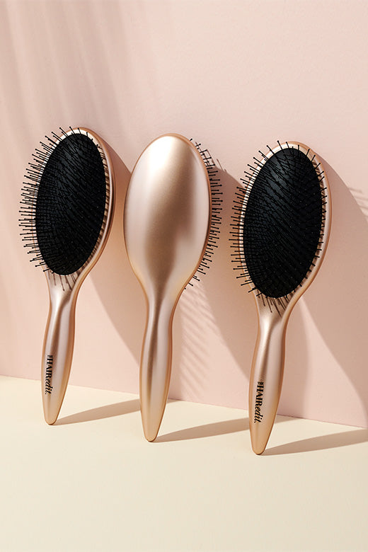 The Hair Edit Detangling & Smoothing Gold Hairbrush display of three brushes
