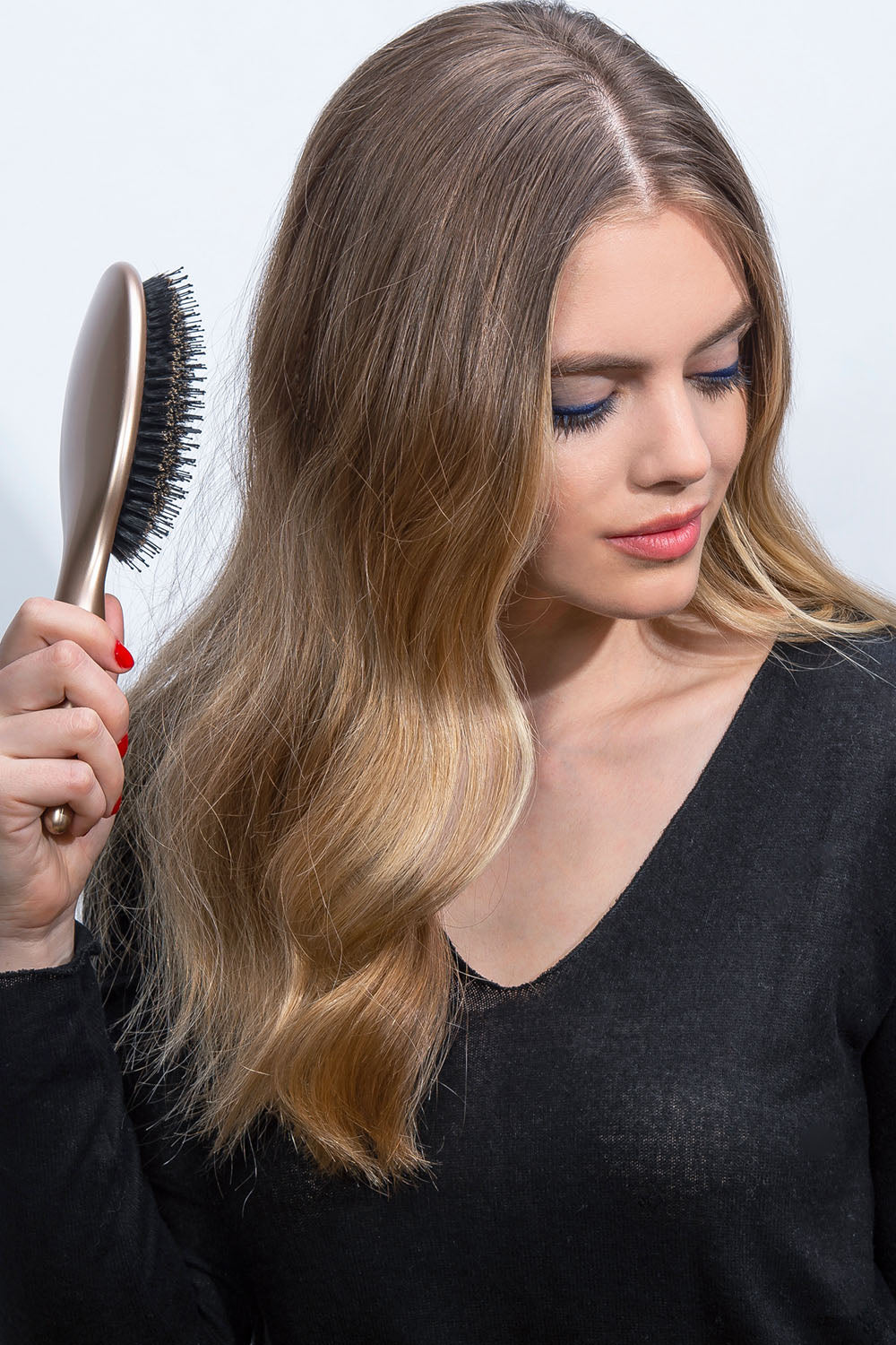 The Hair Edit Finish + Shine Boar Bristle Hair Brush in Gold Color used by medium length haired blonde female model