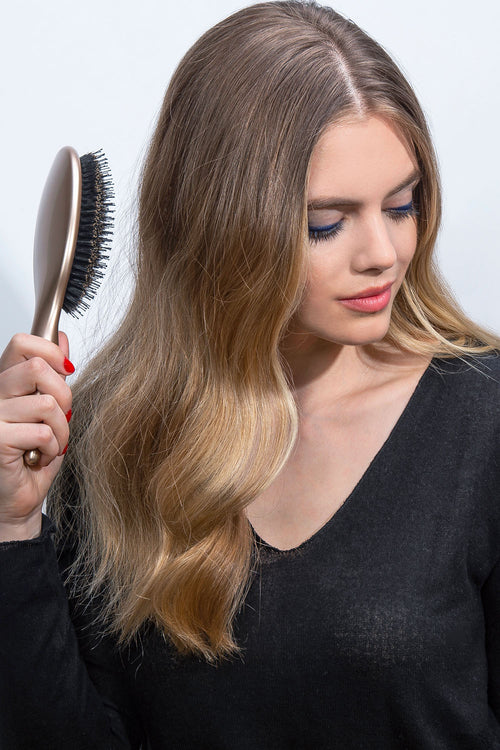 The Hair Edit Finish + Shine Boar Bristle Hair Brush in Gold Color used by medium length haired blonde female model
